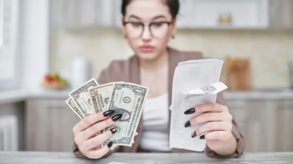 a women looking at bills and money